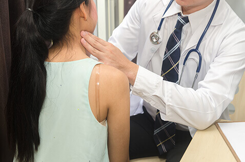 Woman having her neck checked by doctor