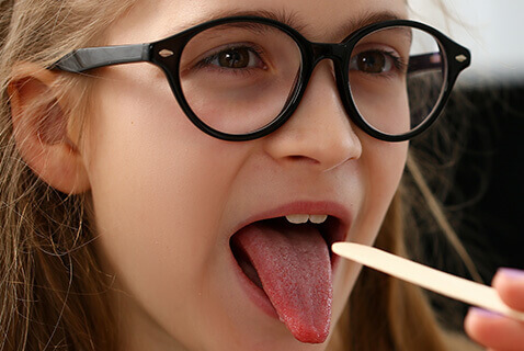 Young girl having throat exam