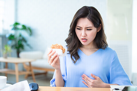 Woman with acid reflux while eating